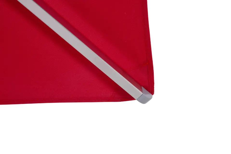 A close-up of the corner of the red Aman umbrella, showcasing the high-quality, weather-resistant fabric, precise stitching, and durable rib end cap.