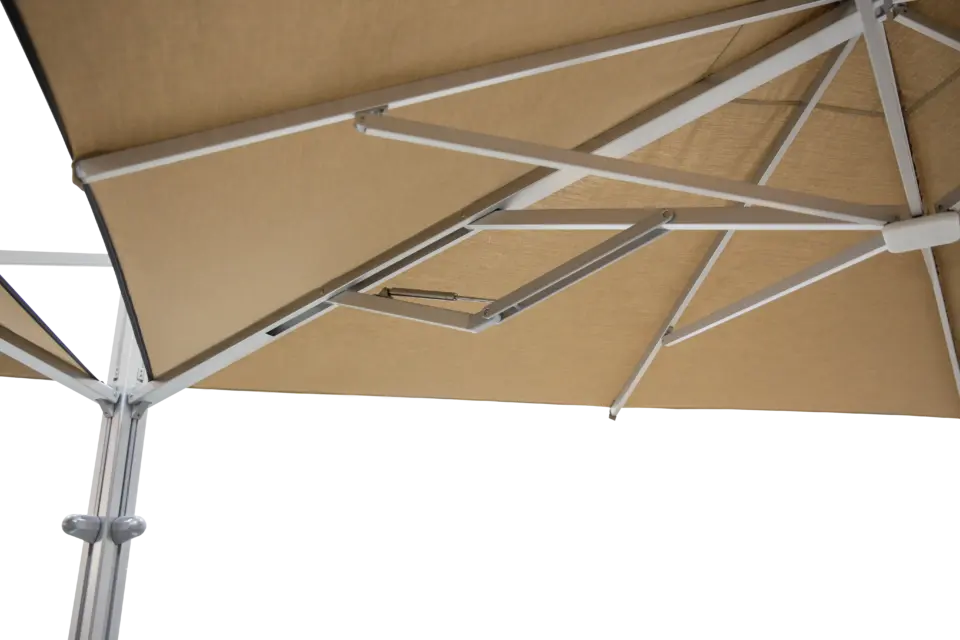 An underneath close-up of the M2 Maximus umbrella, showing the robust aluminum frame and the intricate support structure holding the tan-colored canopy fabric.