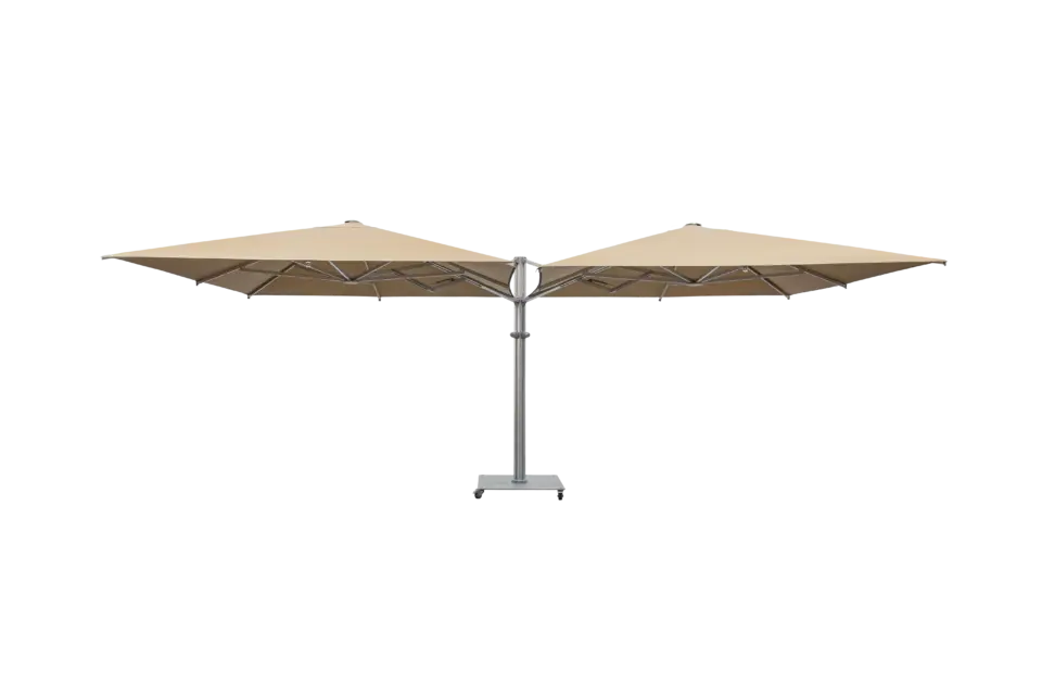 A full-view product shot of the M2 Maximus, a large, tan double-headed parasol with a central aluminum pole and a mobile wheeled base, against a neutral background.