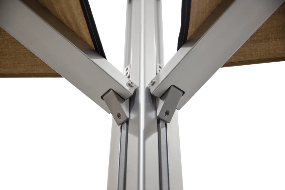 A shot of the central joint on the M2 Maximus umbrella where the dual canopies attach to the main pole, viewed from a low angle against a blue sky.