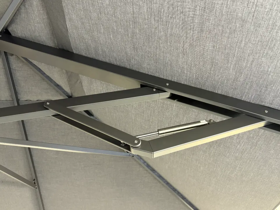 A close-up shot from underneath the V1X canopy, focusing on the internal mechanics and arm structure that allow the umbrella to open and close.