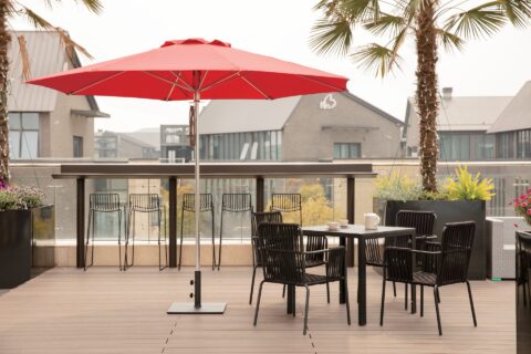 Tempo Bossa Nova umbrella in an outdoor setting with patio furniture.