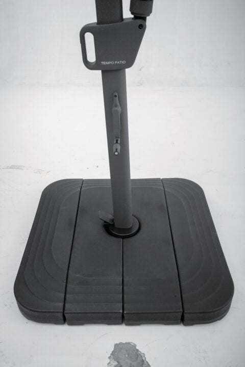 Geneva EZ Lift cantilever umbrella in an outdoor poolside setting with other umbrellas and lounge seating.