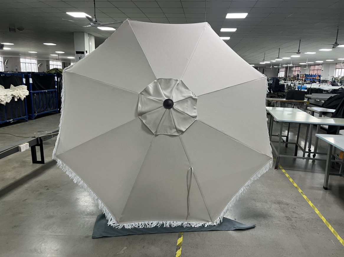Front view of a white commercial umbrella with decorative edging for hospitality use
