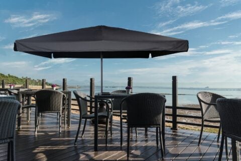 Tempo Piazza umbrella in an outdoor setting, providing shade for a patio seating area.