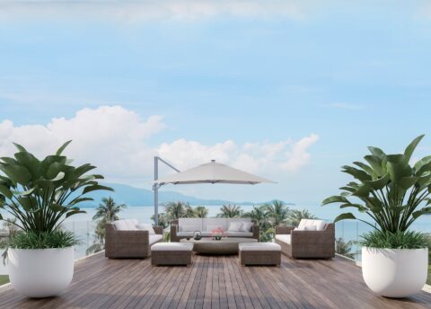 Tempo Utretch umbrella in an outdoor seating area with furniture and ocean view.